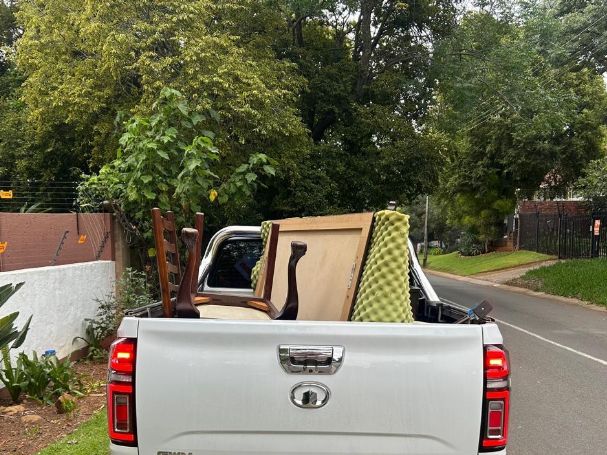 Old wooden furniture loaded on the back of a bakkie